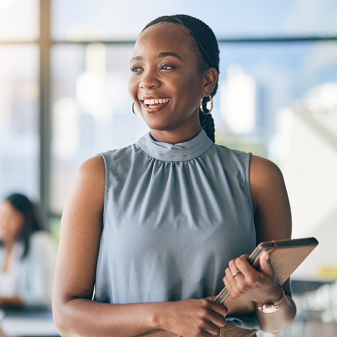 education-i A confident woman smiling as she looks into the distance.